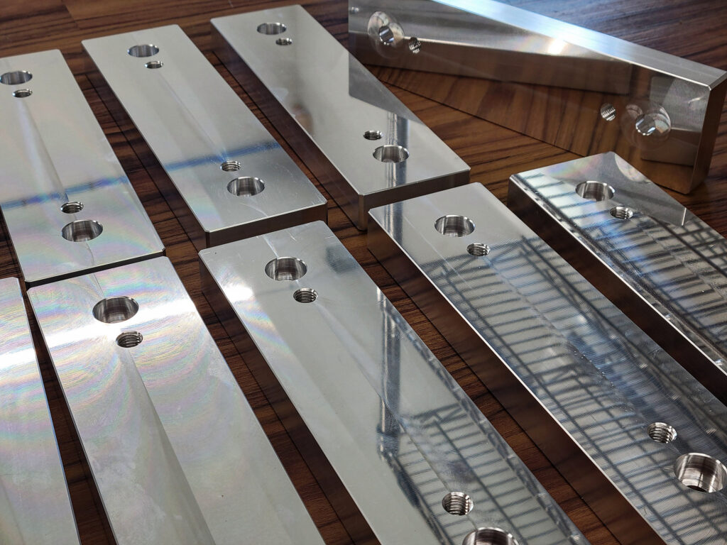 Aluminum manufactured parts with a bright reflective finish.